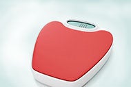 a digital scale with a red top
