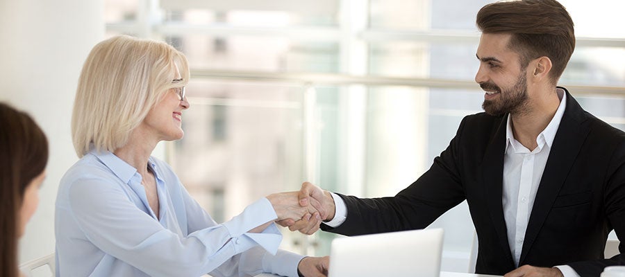 business woman shaking young businessmans