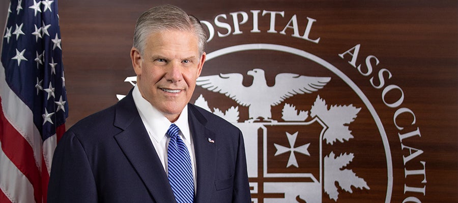 Rick Pollack in front of American Hospital Association seal and American flag