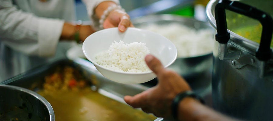 soup kitchen handing out bowl of rice