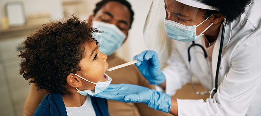 child getting mouth swab from doctor