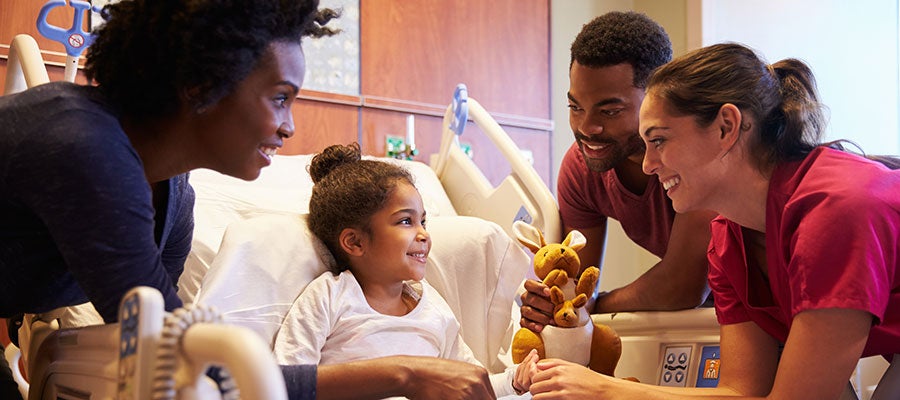 child in hospital being tended to by happy staff