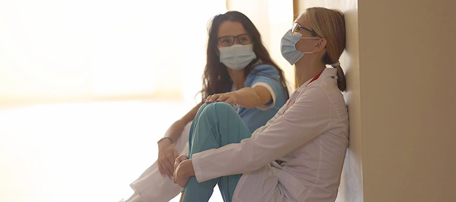 stressed doctor being comforted by coworker