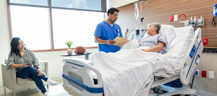 Patient in bed with doctor at bedside 