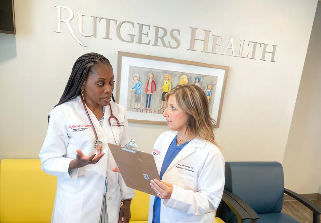 Two Rutgers Health clinician discuss a patient chart.