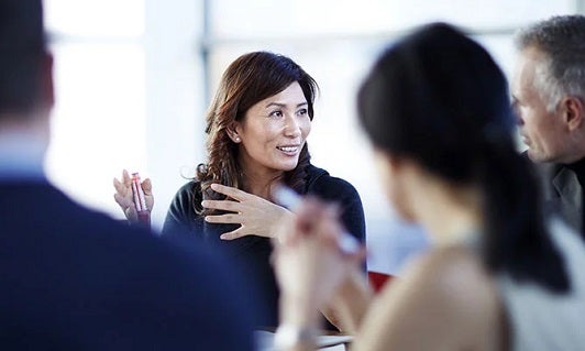 Woman discussing with other business people