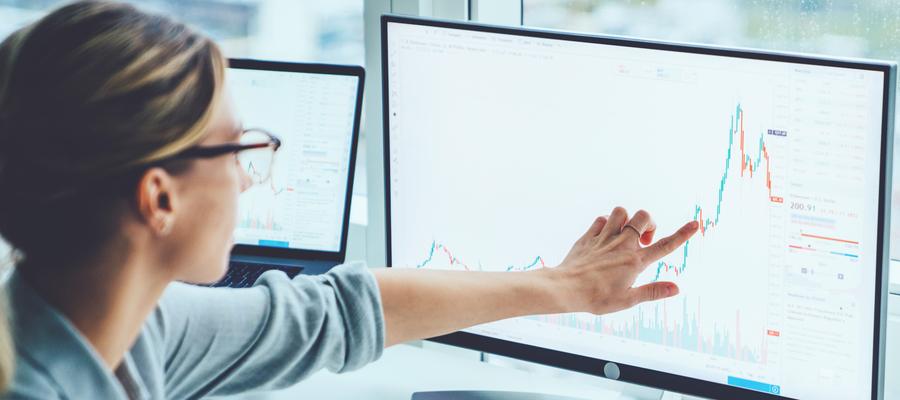A woman looks at a graph on a computer screen